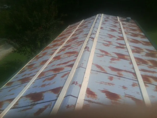 Rusted metal roof panels with new wood purlins before replacement — Storm Damage Roof Repair in Waukomis by Roofing Brothers