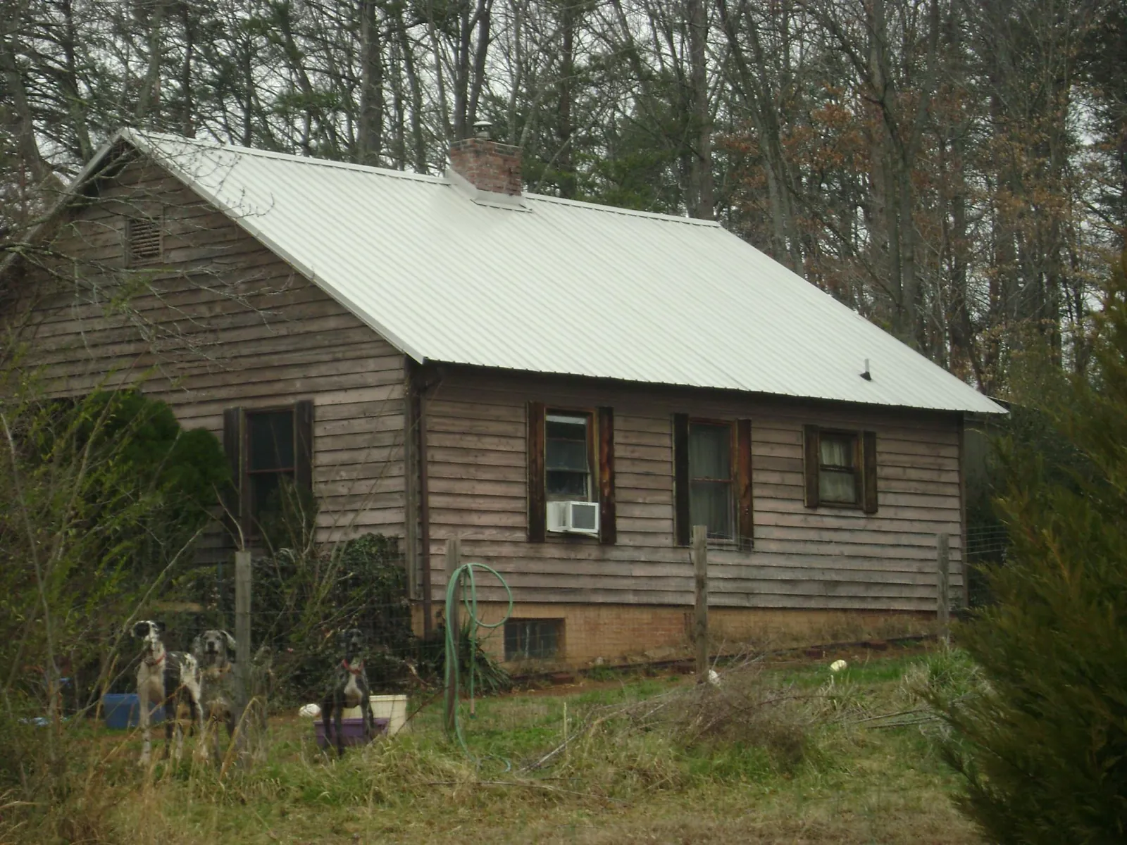 White metal roof on an old wood sided farmhouse, from a Asphalt Shingle Roof Repair job in Waukomis